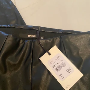 Skinbyxor med slits  - Säljer dessa asballa skinbyxor med slits i stolek xs från bikbok.