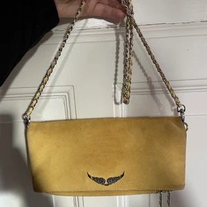 Gul Zadig Voltaire väska  - Gul ovanlig Zadig & voltaire väska som inte går att köpa längre! Den är använd men fortfarande i väldigt bra skick. Inte slitningar på kedjan osv. Ett långt band ingår som syns på bilden. Frakt tillkommer. Pris kan diskuteras vid snabb affär