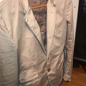 Dondup Kavaj,  - En Beige dondup kavaj som införskaffades för ett tag sedan men har tyvärr inte använts så mycket. Storleken är 48 och passar bra på mig som är ungefär 180cm 73kg. Nypriset låg på ca 4500kr och har suttit prislappen på 600kr + frakt. Vid frågor hör av dig!