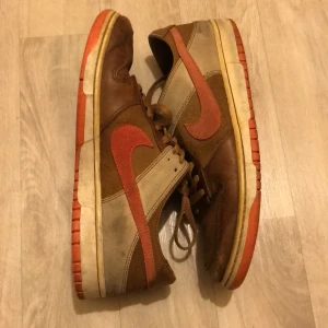 Nike dunk - Nike orange/rosa bruna, vita, mocka, läder dunks. Väldigt unika, köpta från sellpy. Yllesula. Och tunna sidor. Lite sunkigt skick men fortfarande snygga och funktionella.