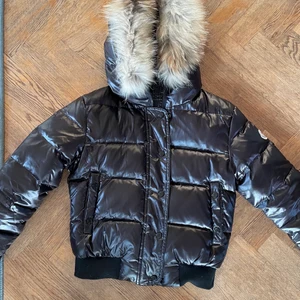 Moncler jacka st 2 - Mörkbrun moncler jacka med pälskrage. Knappt använd och mycket gott skick. Säljes pågrund av att den är förliten.
