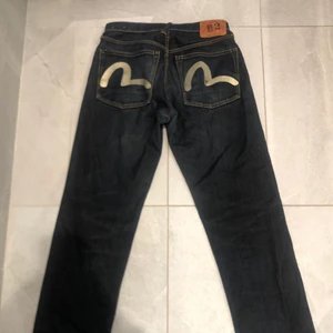 Evisu Jeans - Säljer mina snygga Evisu jeans med vitt tryck på baksidan. Jeansen har små slitage längst ned på baksidan av benen, men annars är de inga problem. Köparen står för frakt, priset kan också diskuteras ;)