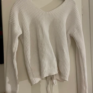 Stickad tröja med snörad rygg - Vit stickad tröja från nelly, ryggen är snörad, gör att bestämma själv hur öppen ryggen ska vara. Storlek S sitter även bra på M. Skriv för mer bilder💕
