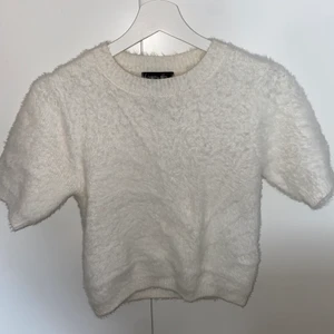Fluffig vit t-shirt från ASOS - Fluffig mysig vit t-shirt köpt från ASOS i storlek S som jag inte använt mer än 3 gånger,  säljer jag vidare för att den ska få mer användning. 