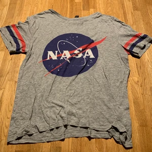 Gray t-shirt NASA - This t-shirt gives space vibes. It’s perfect for every weather, and it’s very flexible and a perfect length.