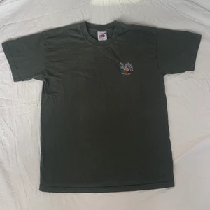 Grön T-shirt med tryck  - En snygg mörkgrön T-shirt från Fruit of the Loom med en fågel broderad på. Storlek M, passar lite oversized. Mycket bra skick. Köparen står för frakt💚