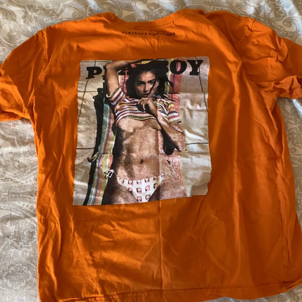 En orange T-shirt med märket Playboy som knappt är använd  och inga direkta tecken på användning, skriv för mer info . T-shirts.