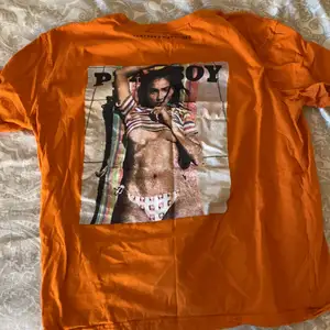 En orange T-shirt med märket Playboy som knappt är använd  och inga direkta tecken på användning, skriv för mer info 