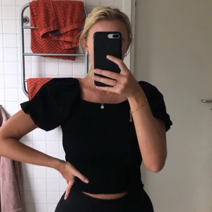 Topp från Ginatricot - Snygg svart topp från Gina Tricot i storlek L (liten i storleken). Helt ny, lapp sitter kvar. Den är ribbad över livet och ärmarna är lite ”puffiga”.