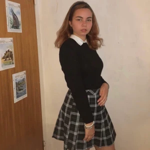 Kort svart kjol med veck  - Svart grårandig veckad kjol från H&M.