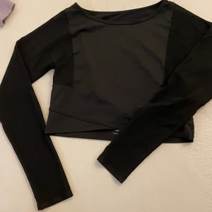 Träningströja  - En svart träningströja som är kortare i modellen och har mesh på armarna 