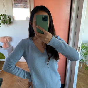 Merinoull tröja - Mysig finstickad tröja från Benetton i ljusblå merinoull med v-ringning. I perfekt skick! Använd bara 2 gånger. 