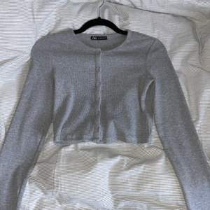 Säljer denna gråa tröja/topp från Zara. Säljer pga att jag inte använder den. Den är långärmad och super skön. Det är tjock material och har knappar. Den är aldrig använd och är i storlek S. Köparen står för frakten!💕 