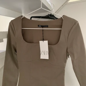 Body i brun/beige - Säljer denna superfina body från Zara då den var lite för liten! Storlek XS! Nypris 259kr! Aldrig använd med lappar kvar❣️köparen står för frakten