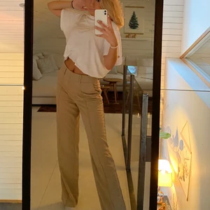 Beige kostymbyxor  - Säljer ett par beiga kostymbyxor från Nakd. Jättesnygg slits i bak också 