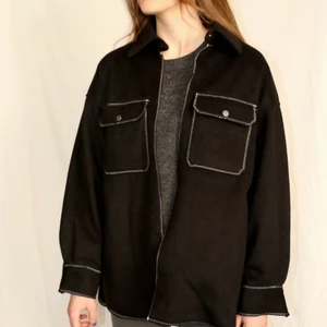 Jacka med vita sömmar - Svart jacka i skjort-modell. Vita sömmar. Ursprungligen från H&M som är omgjord av Scannable UF. Genom att skanna en QR-kod som finns fäst på plagget kan du läsa mer om materialet och dess miljöpåverkan!✨✨
