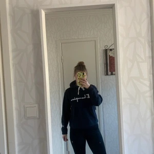 Champion hoodie STL: M - En snygg mörkblå hoodie från champion som ger en lite oversizedlook. Jag har vanligen XS-S och hoodien är i M och sitter bra. Därför är den lite liten i storleken. Färgen syns bäst när tröjan är på!🤩 Den är använd 2 gånger och är i nyskick. Köparen står för frakt 