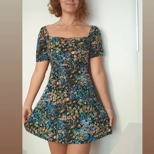 Färgglad sommarklänning med mindre puffärm - Figurnära blommigt blå, turkos och orange polyesterklänning från Pull&Bear storlek M=fast S egentligen, 80cm lång (44 cm ner från midjan. I gott skick. Jag är 168 cm, när man böjer sig ner behövs shorts under. Pris+frakt =slutpris 150kr 