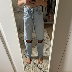 Blåa jeans med hål - Hej! Jag säljer dessa blåa jeans med hål från zara i strl 32/xxs. andvända några ggr men är i fint sick, inga fläckar.