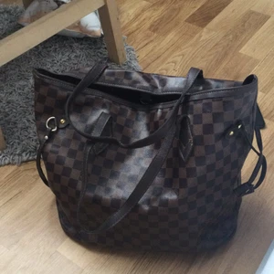 Väska  - En väska med en blånbok i som med följer det är en lite ficka på in sidan av väskan i fint skick 