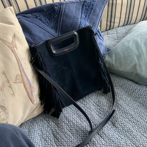 Maje väska  - Säljer min maje väska, köpt för ca 1,5 år sedan och är använd några gånger. Mocka och ej impregnerad, kan finnas små ojämnheter på väskan pga den är i mocka som man ser på bild 1 vid bandet,  men den är i väldigt bra skick. Köpt för 2700kr i Köpenhamn. Kvitto finns (inte lilla modellen)