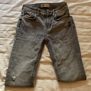 Gråa zara jeans  - Gråa jeans från zara i stl 34. Jätte fina men tyvärr lite små för mig. Är sparsamt använda och inga hål eller andra tydliga slitningar. Lite lägre midja men inga lowwaist. Köpta för ca 2 år sedan💗 skriv för mer info vid intresse💗💗