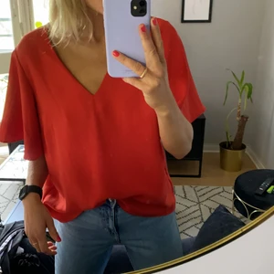 Kortärmad blus från H&M - Kortärmad röd blus från H&M. Ärmarna är vida. Storlek 42. Gott skick.