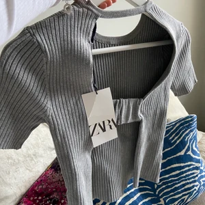 Zara topp grå - Jättefin topp från zara med öppen rygg och ser som vanligt ut fram till. Helt oanvänd