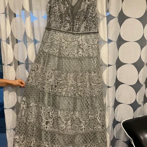 Fest klänning stl 46-48 (L-XL)  - Fest klänning silver stl 46-48 (L-XL) , använd 1 gång i några timmar, dragkedja där bak som går ner till ryggen. Inte genomskinlig. Köparen står för frakten 99kr. Står ej för postens slarv! Finns mer bilder och videos om du är intresserad. 