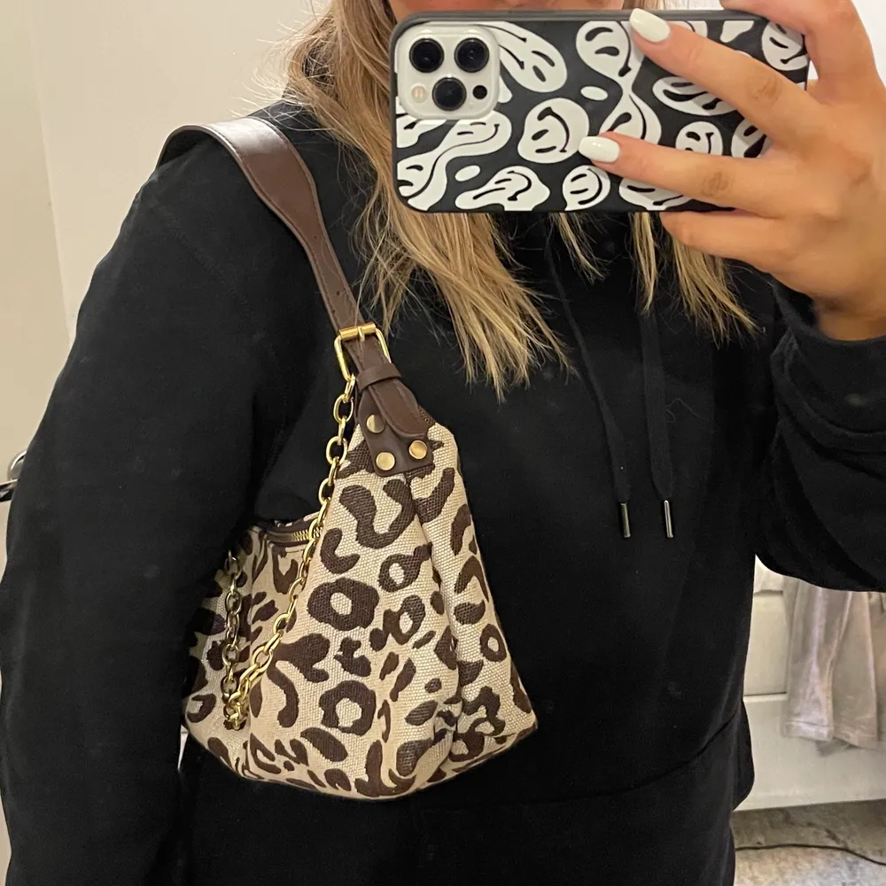 Beige brun väska med leopard mönster och gulddetaljer. Köparen står för frakt . Väskor.