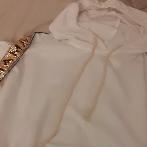 Hoddie - Vit hoddie me text på sidan på armarna, köparen står för frakten