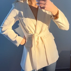 Oversized blazer från Mango, i storlek 36/S - En klassisk krämvit oversized blazer/kavaj, men ett snöre som går att knyta i midjan men som går att ta av. Den är i fint skick och använd ett par gånger. Storleken är 36/S, men oversized som går att se på bilderna.