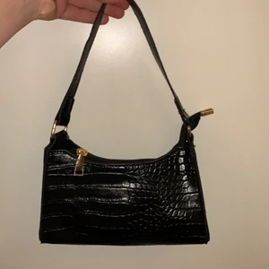 Väska - Väska från shein o säljer för 30+ frakt ( köparen betalar för frakten!) Size: liten men gullig, svart med lite ”ormskinn” väldigt fin o aldrig användt! Dragkedjan är lite trög men har aldrig användt den så är nog därför, helt svart inuti och har inga fickor!! 