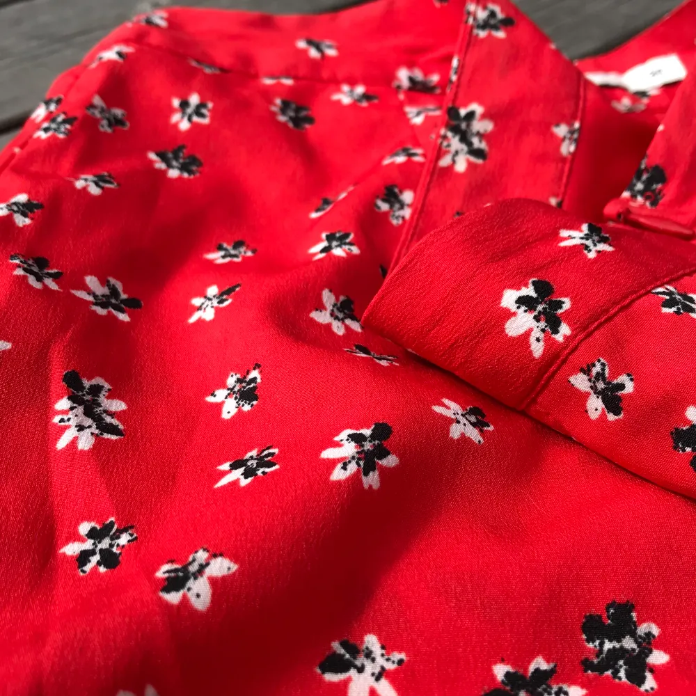 Röd blommig kjol, väldigt fin och somrig men som tyvärr blivit lite för liten. Använd 2 - 3 ggr. Strl: 34 . Kjolar.