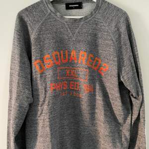 Made in Italy sweatshirt från Dsquared2 i i fräck varierande grå färg med oranget tryck. Strl L. Sparsamt använd, nypris 2.300 kr. 