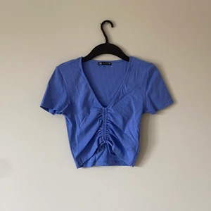 Blå Scrunch Top från Zara! - Jättesöt kortare topp från Zara! Storlek M! Köpt för 200 kr, säljer för 100 kr + frakt💕💕💕💜 Fin till sommaren!