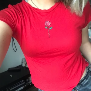 Röd topp med tryck - Superfin röd topp med ett ros tryck. Säljer då den är lite för liten ❤️