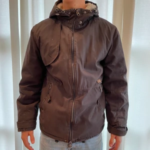 Vinterjacka  - Brun/grå vinterjacka. Använd men är i ett fint skick. Storlek S, modellen på bilden är 180cm lång. 