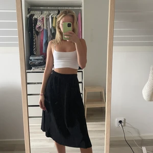 Svart ribbad medellängds kjol - Svart medellängds kjol i ribbat material, jättefin passform. (köpt från BikBok)