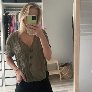 Mörkgrön blus med knappar - Använt den som oversize blus då den är i storlek M, superfin med knappar och en ficka på framsidan. (köpt från BikBok)
