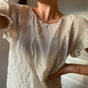 Custommade topp - Säljer denna populära glittertoppen från custommade. Beige med silver detaljer. Har ett medföljande underlinne. Använd ca 5 gånger