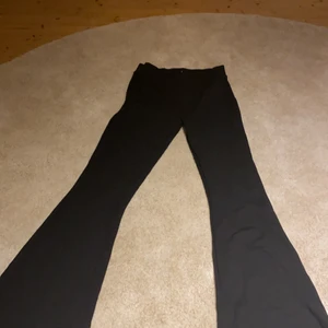 Svarta yoga pants  - Ett par svarta bootcut byxor i mjukt material (yoga pants) Från Ginatricot storlek M men skulle även kunna passa S. Aldrig används och de är i ett tjockare material än vissa andra av dessa slags byxor så de är inte genomskinliga.