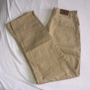 Beige jeans från Nelly  - Jeans från Nelly i storlek 38 med slit nertill. Frakt tillkommer 