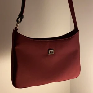 Vintage ”GUESS” VÄSKA - En vinröd axelväska. Vintage, finns innerficka även ficka på andra sidan. G:et är exakt som märket GUESS G. 150kr!!!😍😍😍
