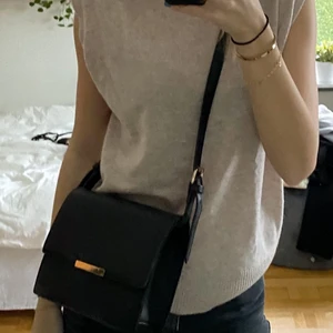 Svart väska med gulddetaljer - Svart väska i fakeskinn med gulddetaljer och långt justerbart band⚡️ fint skick men säljer pga flytt