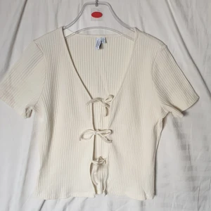 &Other Stories Top - Top från &Other Stories (deras Paris Ateliér linje) med tre knutar på framsidan. 🌃 Materialet är av hög kvalitet och är ribbad. Toppen ser lite gulare ut i kameran men skulle säga att den är Creme White. 😊 Nyskick, bara använd 1 gång. Nypris: 590kr