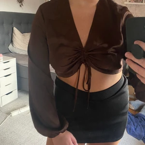 Glansig top🤎 ASOS - Säljer denna super snygga top från ASOS då jag tyvärr fick hem den i fel storlek och är lite stor för mig vid brösten😕 Aldrig använt den utan endast testat, köpt för bara någon månad sedan, så super bra skick🥰