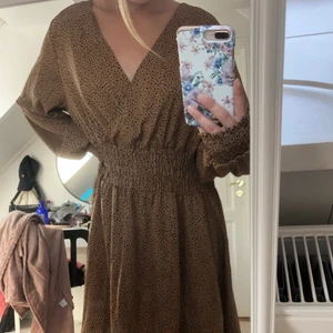 Jätte fin brun klänning  - Säljer åt mamma! För liten för mamma tyvärr, & hjälper henne att sälja den! (Bilderna är tagna när jag har på den)! Jätte fint skick & inga defekter, aldrig använd men sälj pga att den är för liten! Skriv om du har någon fråga eller om du vill ha fler bilder! (Sista bilden syns hur lång den är) 