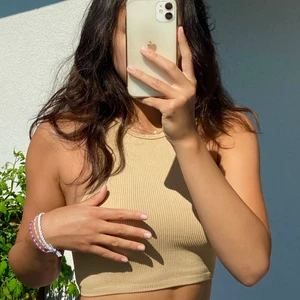 Nude halterneck - Croppad, nude, halterneck linne från Zara! Säljer då den inte kommer till användning längre.