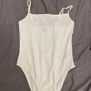 Vit linne bodysuit - Jätte fint linne som även är en body suit! Köpt ifrån gina tricot i storlek M, tröjan är dock stretchig men formar sig efter ens kropp. Bodyn gar knappar som man knäpper nere vid änden! Säljer eftersom den inte kommer till användning längre! Skriv gärna om ni är intresserade eller har frågor/ vill se mera bilder på hur tröjan ser ut ex hur den sitter på osv❤️ pris kan diskuteras!